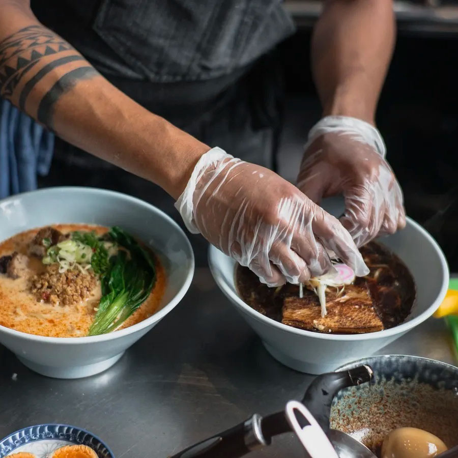 photo of chef hands preparing Asian cuisine in a bowl.