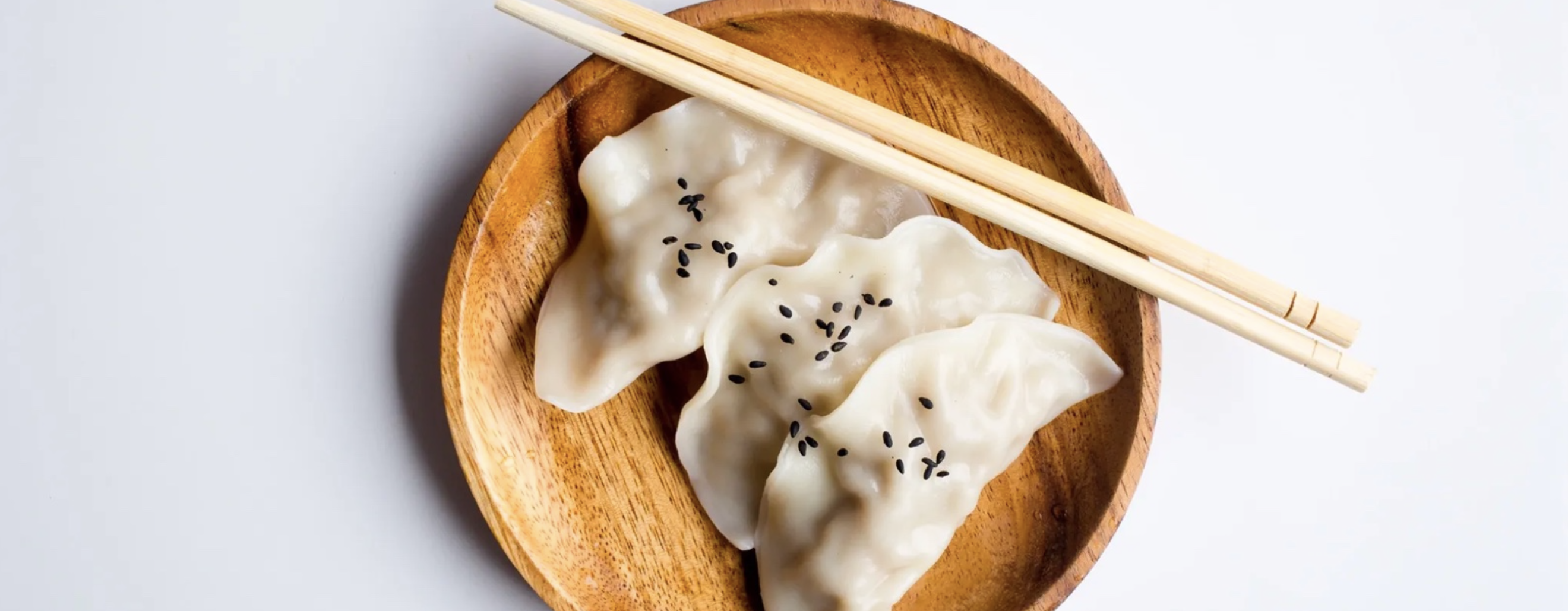 photo of a Asian dumplings in wood bowl.
